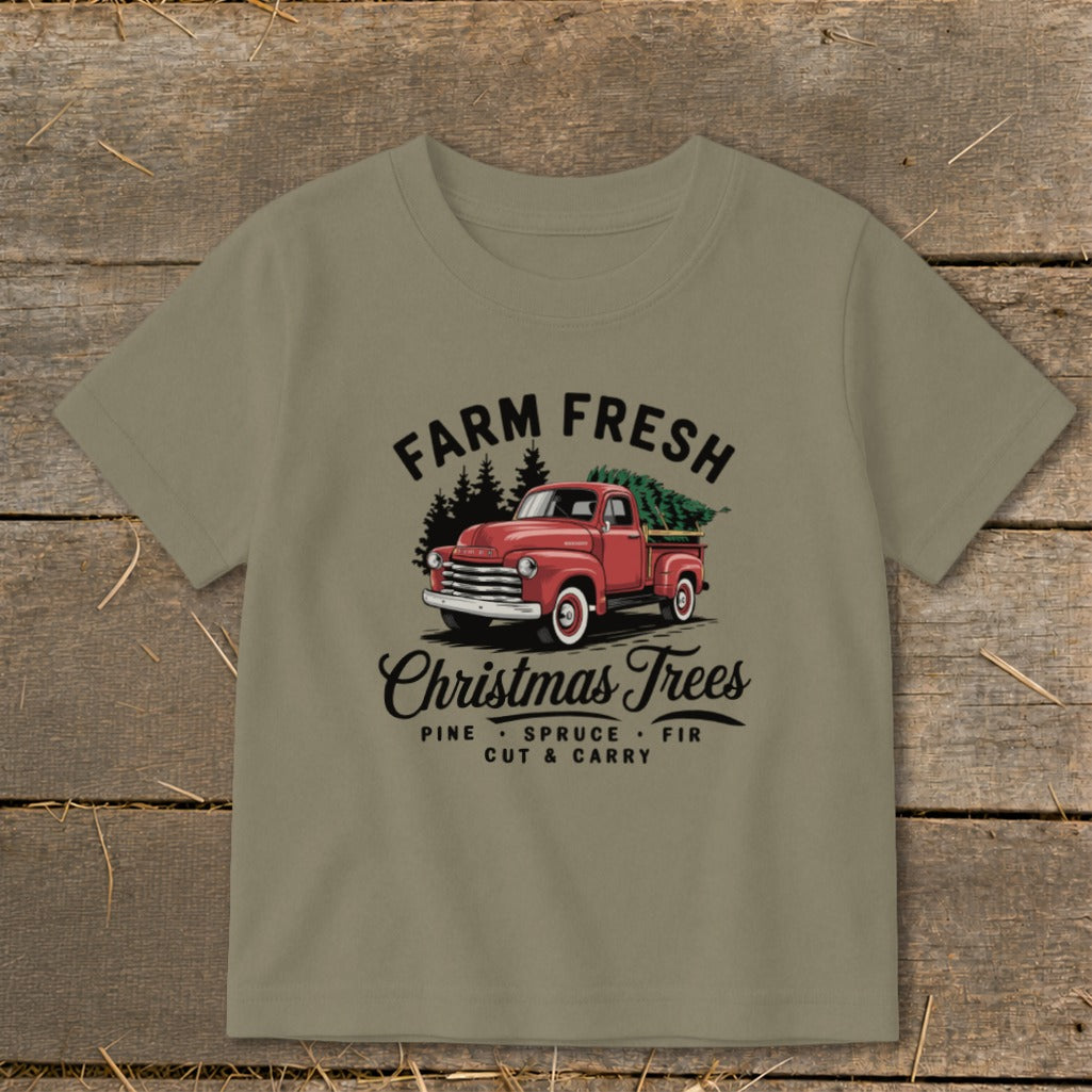 T-shirt graphic with red truck carrying Christmas trees and text "Farm Fresh Christmas Trees".