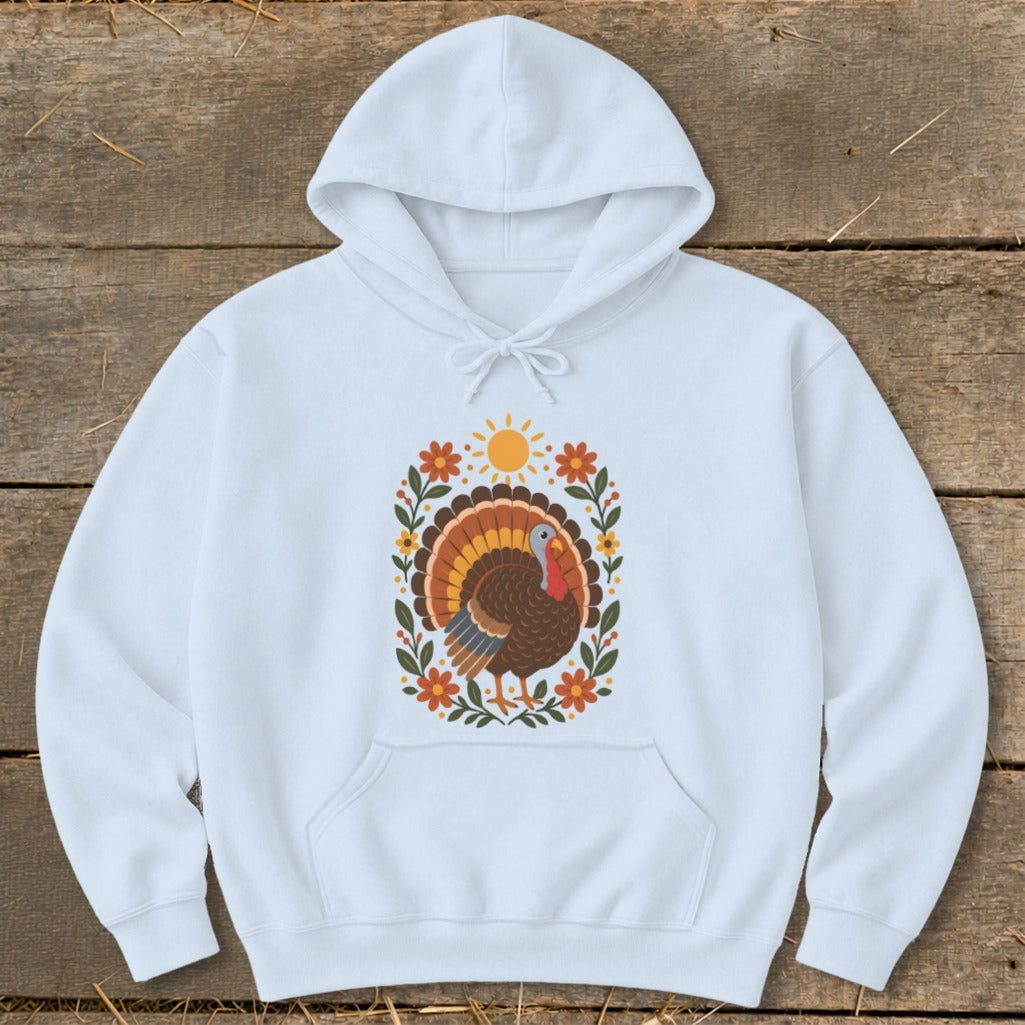 White hoodie with a floral turkey design featuring a sun and autumn leaves.
