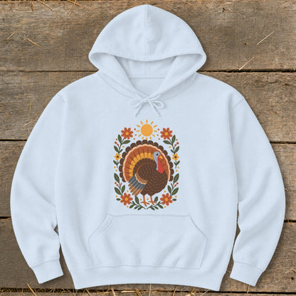 White hoodie with a floral turkey design featuring a sun and autumn leaves.