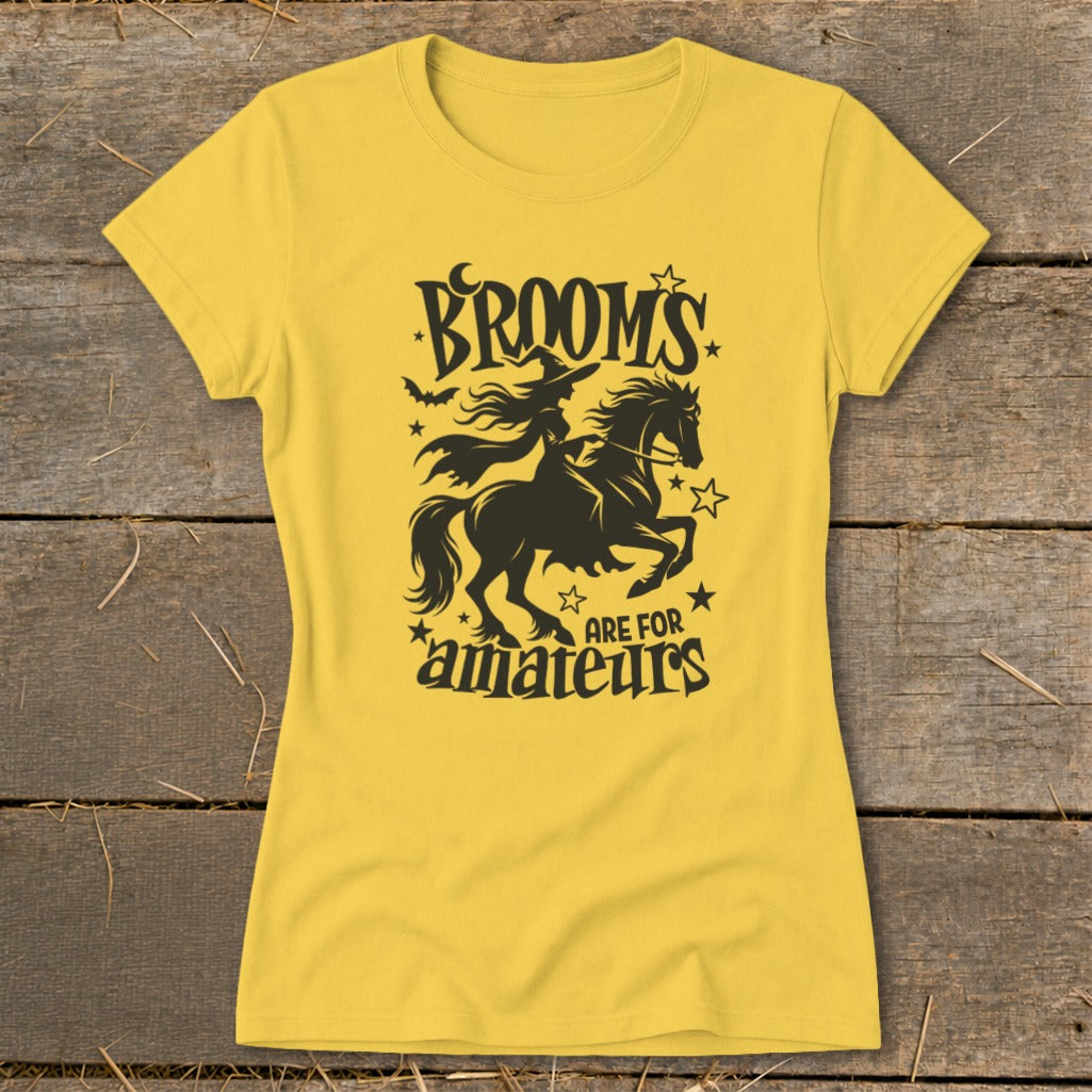 Yellow t-shirt with black graphic of a witch riding a horse, text "Brooms are for amateurs."