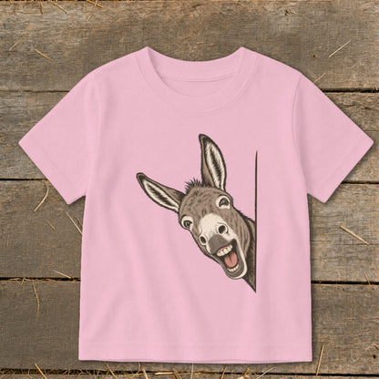 Pink t-shirt with a cartoon donkey peeking around a corner with a wide grin.