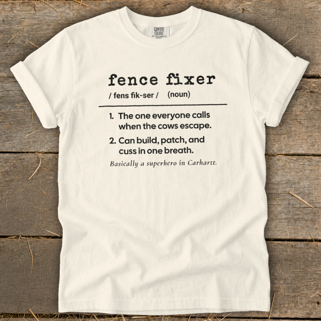 White t-shirt with "fence fixer" definition and rural background.