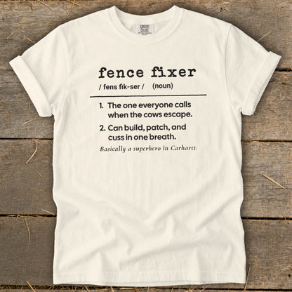 White t-shirt with "fence fixer" definition and rural background.