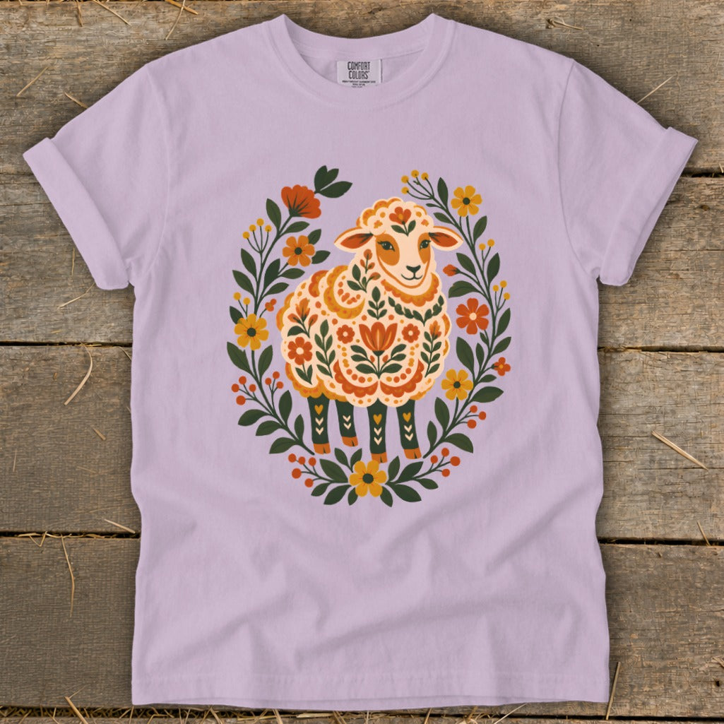 Lavender t-shirt with folk art sheep surrounded by flowers and leaves.