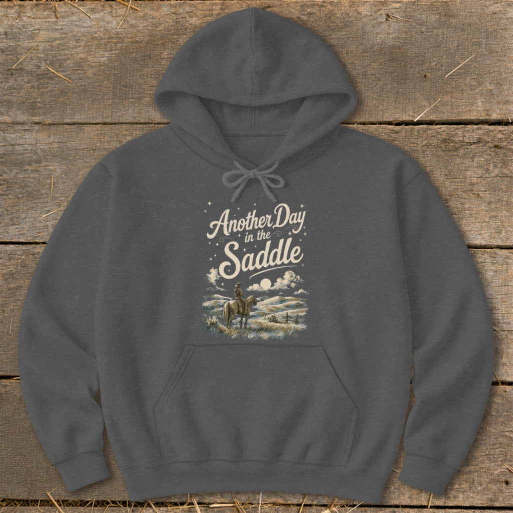 Dark gray hoodie with "Another Day in the Saddle" text and cowboy on horseback graphic.