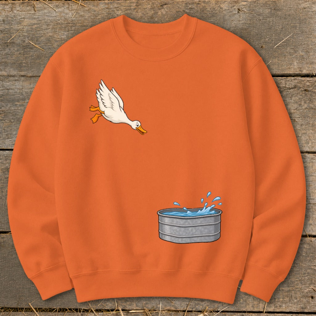 Orange sweatshirt with cartoon duck jumping into a galvanized tub of water.
