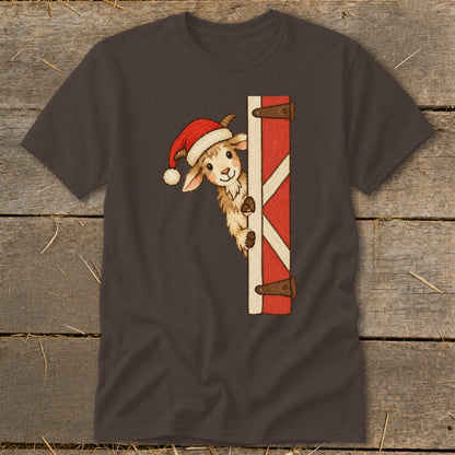 Brown t-shirt with a cartoon goat wearing a Santa hat peeking around a red barn door.