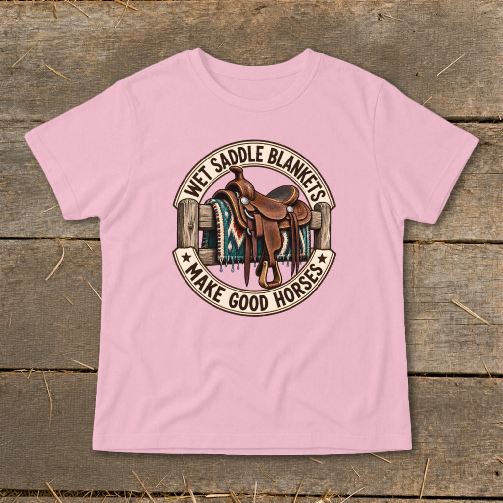 Pink t-shirt with a circular graphic of a western saddle and blanket on a fence.