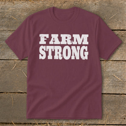 Maroon short-sleeved t-shirt with distressed white text reading "FARM STRONG" displayed centrally.