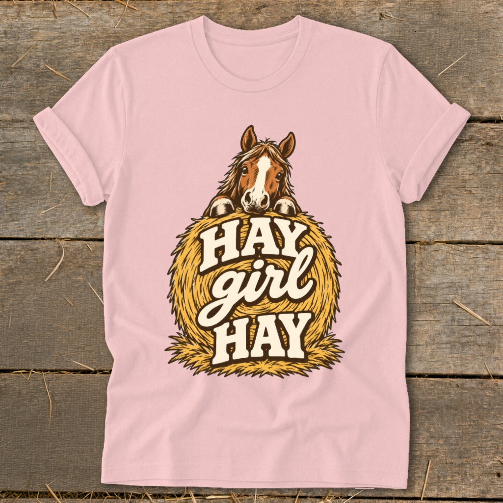 Pink t-shirt with a horse peeking over a hay bale with text "HAY girl HAY".