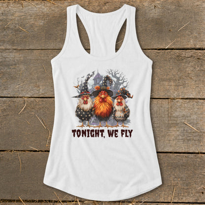 Three chickens wearing witch hats stand before a spooky house. "TONIGHT, WE FLY" text.