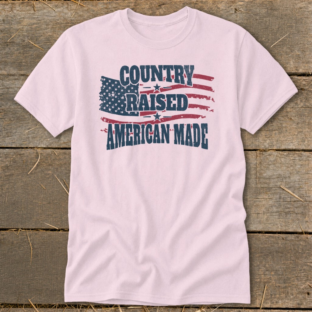 Light pink t-shirt with distressed American flag graphic and text: Country Raised American Made.