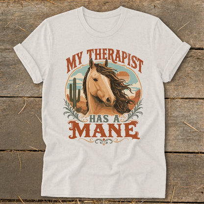 Light-colored t-shirt with horse graphic and text "My Therapist Has A Mane".