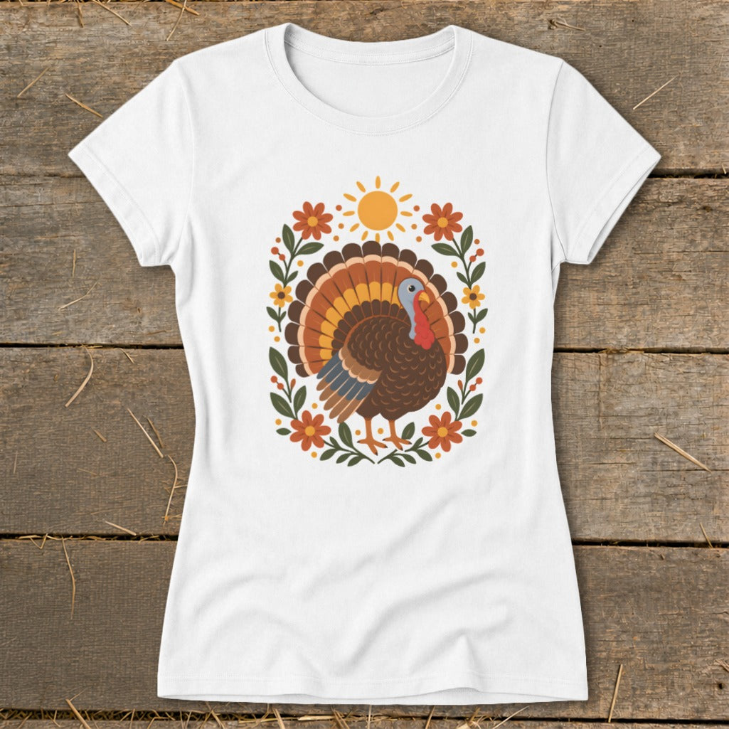 White t-shirt with a cartoon turkey surrounded by flowers and a sun graphic.
