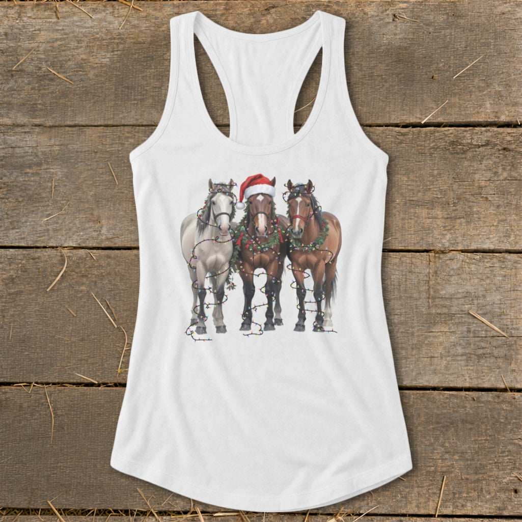 Three horses wearing Christmas lights and garlands on a white tank top.