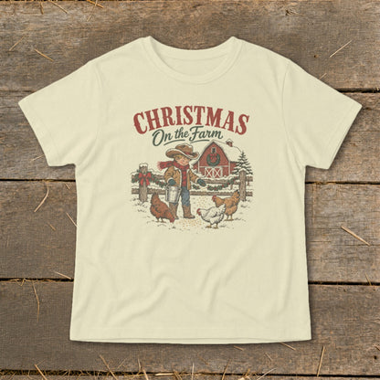T-shirt with Christmas on the Farm graphic: boy feeding chickens by barn.