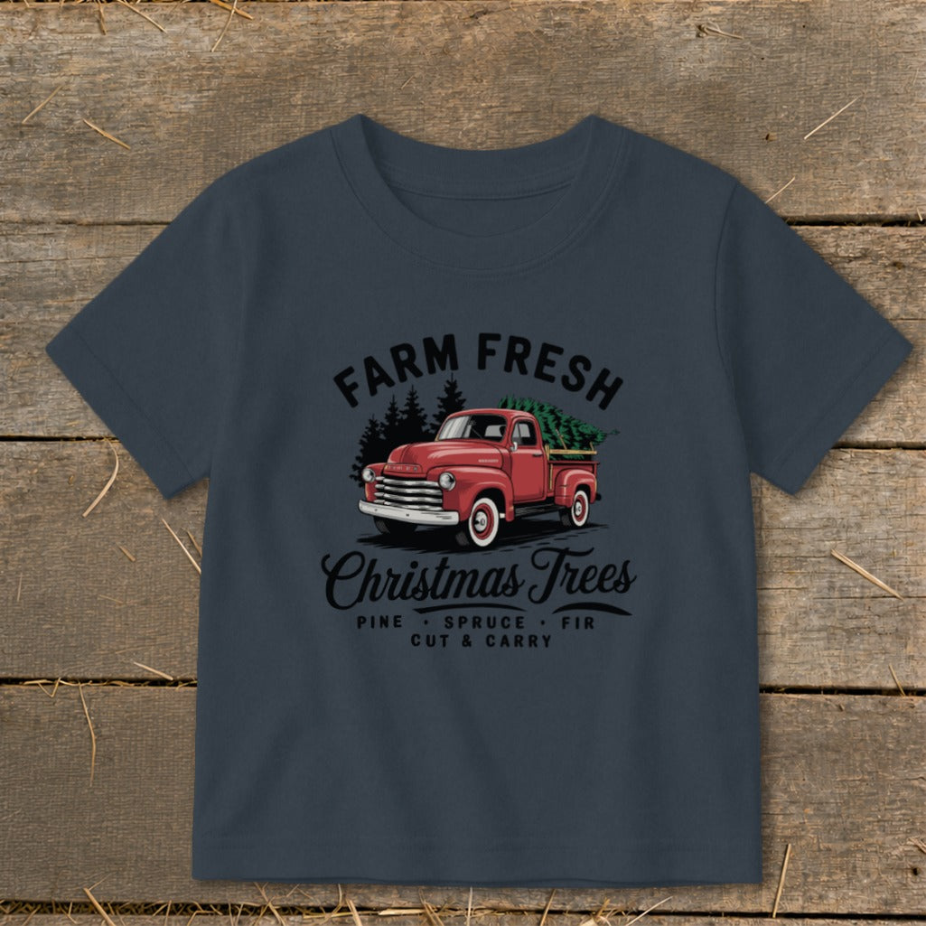 T-shirt with a red truck carrying a Christmas tree and the text "Farm Fresh Christmas Trees".