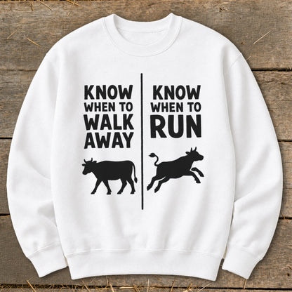 White sweatshirt with black text and cow silhouettes: "Know When to Walk Away" and "Know When to Run".