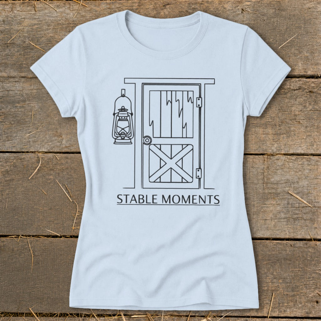 Light blue t-shirt with line drawing of stable door and hanging lantern, "STABLE MOMENTS" text.