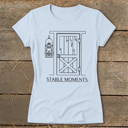 Light blue t-shirt with line drawing of stable door and hanging lantern, "STABLE MOMENTS" text.