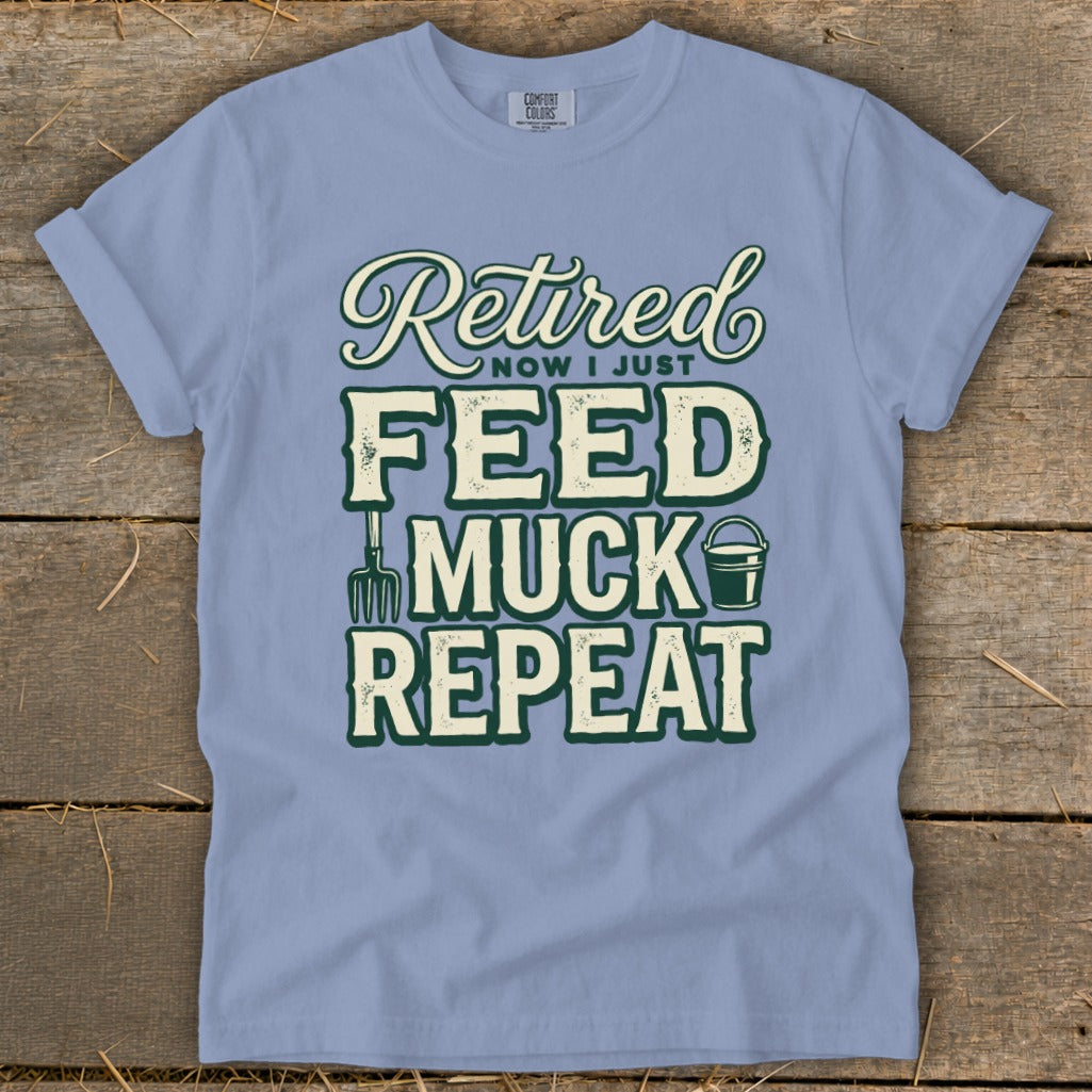 Light blue t-shirt with "Retired Now I Just Feed Muck Repeat" graphic.