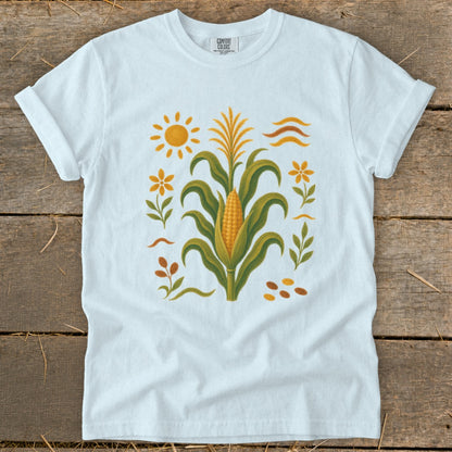 White t-shirt with a corn stalk, sun, flowers, and leaves graphic.