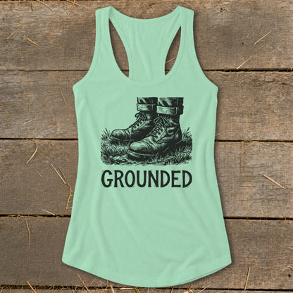 Mint green tank top with illustration of boots in grass and the word GROUNDED.