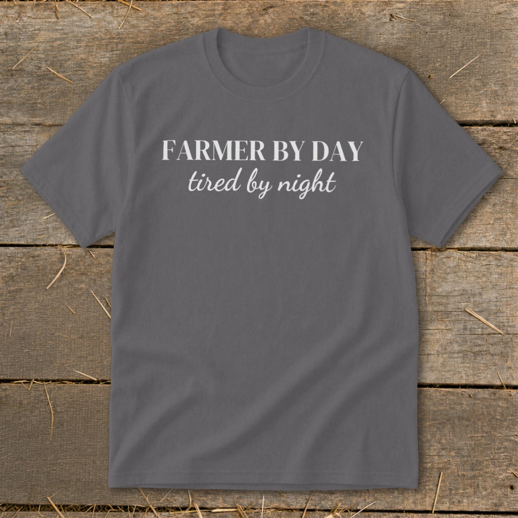 Dark grey t-shirt with white text reading "FARMER BY DAY tired by night."