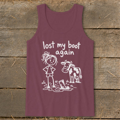 Maroon tank top featuring white graphic text that reads lost my boot again, with a sad girl and a cow standing near a boot in a mud puddle.