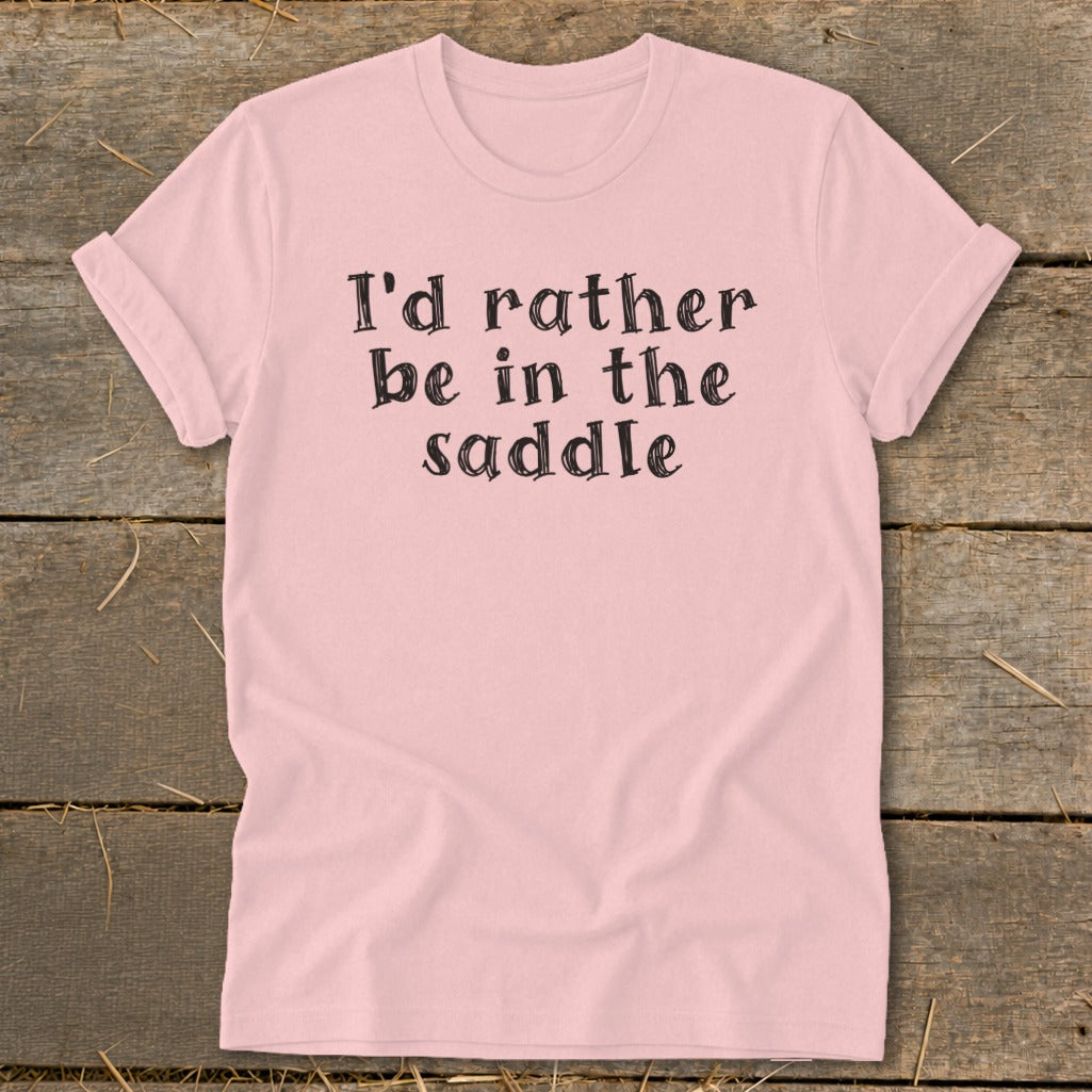 Pink t-shirt with black text that reads "I'd rather be in the saddle."