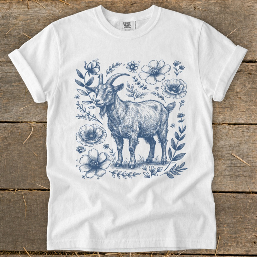 White t-shirt with blue sketch of a goat surrounded by flowers and leaves.