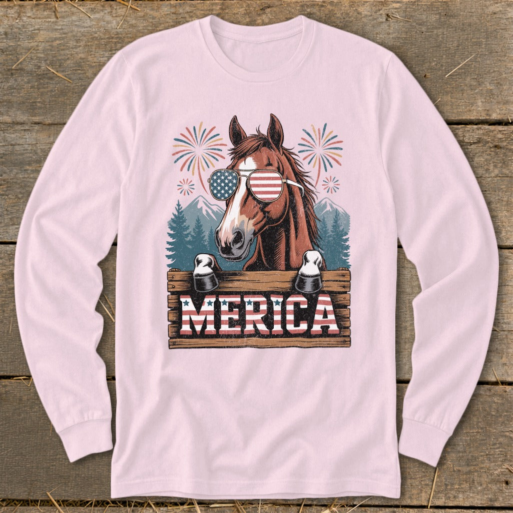 Horse wearing American flag sunglasses, "MERICA" text on wooden sign, fireworks and mountains background.
