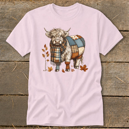 Highland cow with plaid scarf and patchwork body, surrounded by autumn leaves.