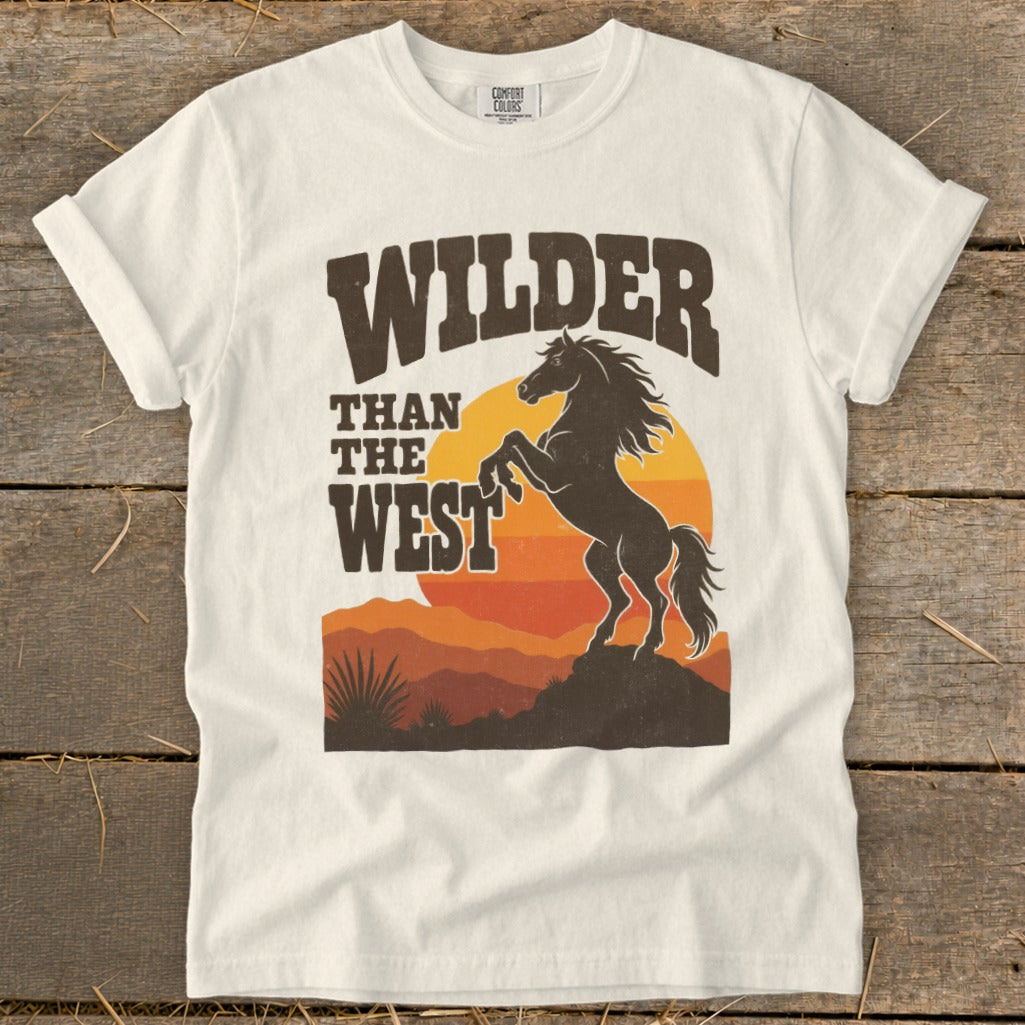 White t-shirt with a graphic of a bucking horse and text "Wilder Than The West".