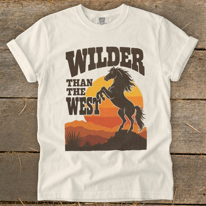 White t-shirt with a graphic of a bucking horse and text "Wilder Than The West".