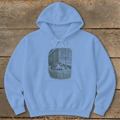Light blue hoodie with a drawing of a sleeping cat in a barn during a snowfall.