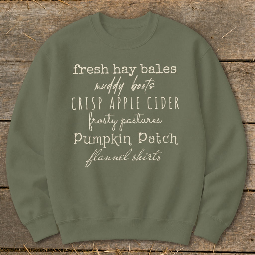 Olive green sweatshirt with list of autumn phrases in white text.