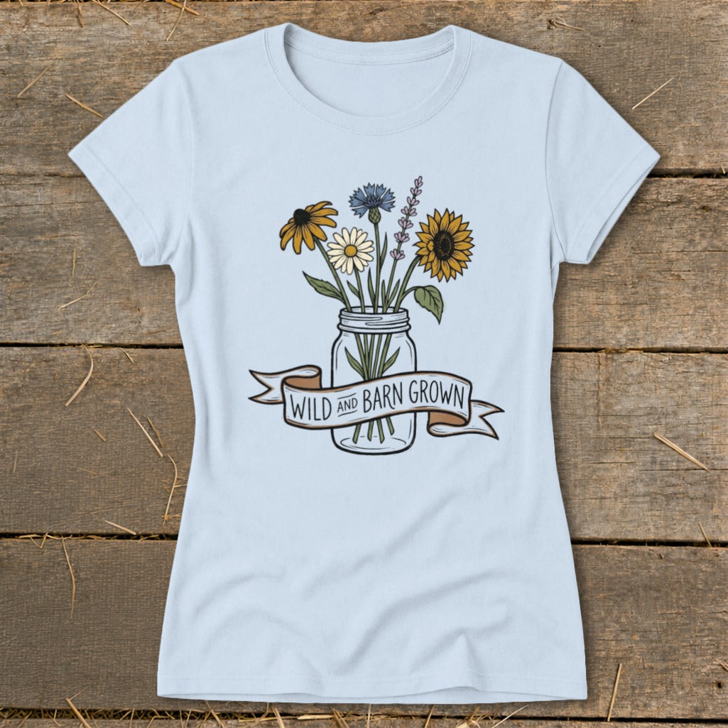 Light blue t-shirt with a mason jar of wildflowers and a banner reading "WILD AND BARN GROWN".