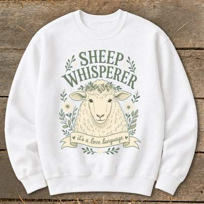 White sweatshirt with a sheep graphic and text "Sheep Whisperer it's a love language".