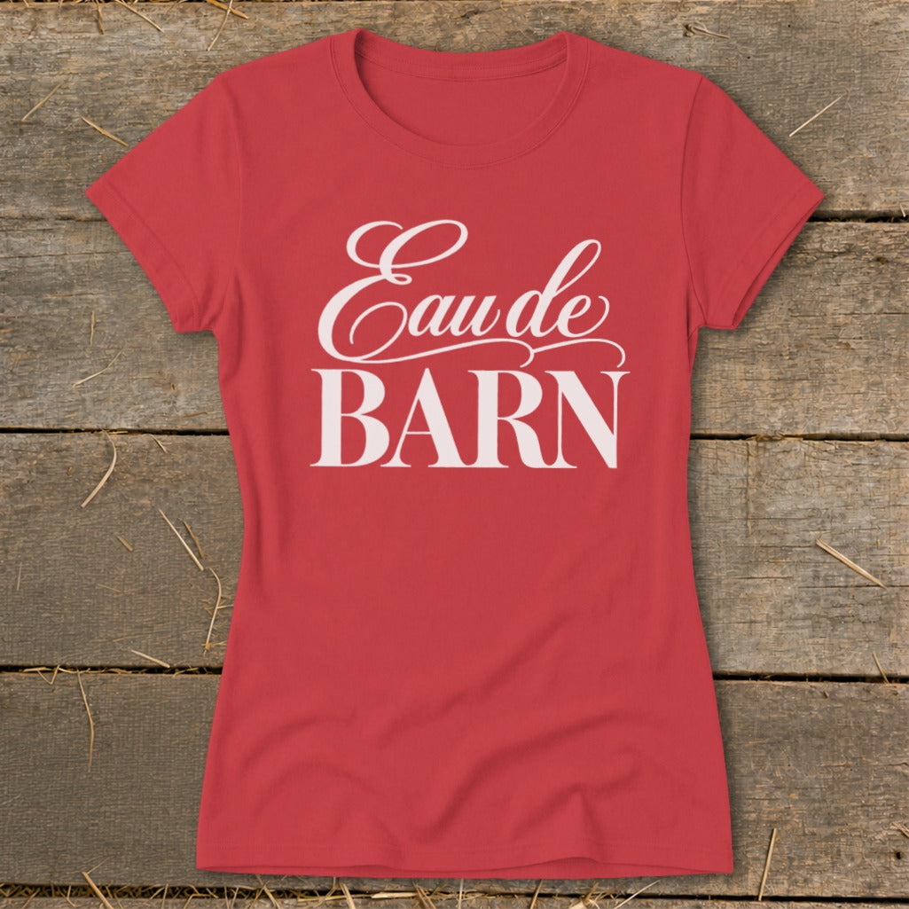 Red t-shirt with white text "Eaude BARN" on wooden background.
