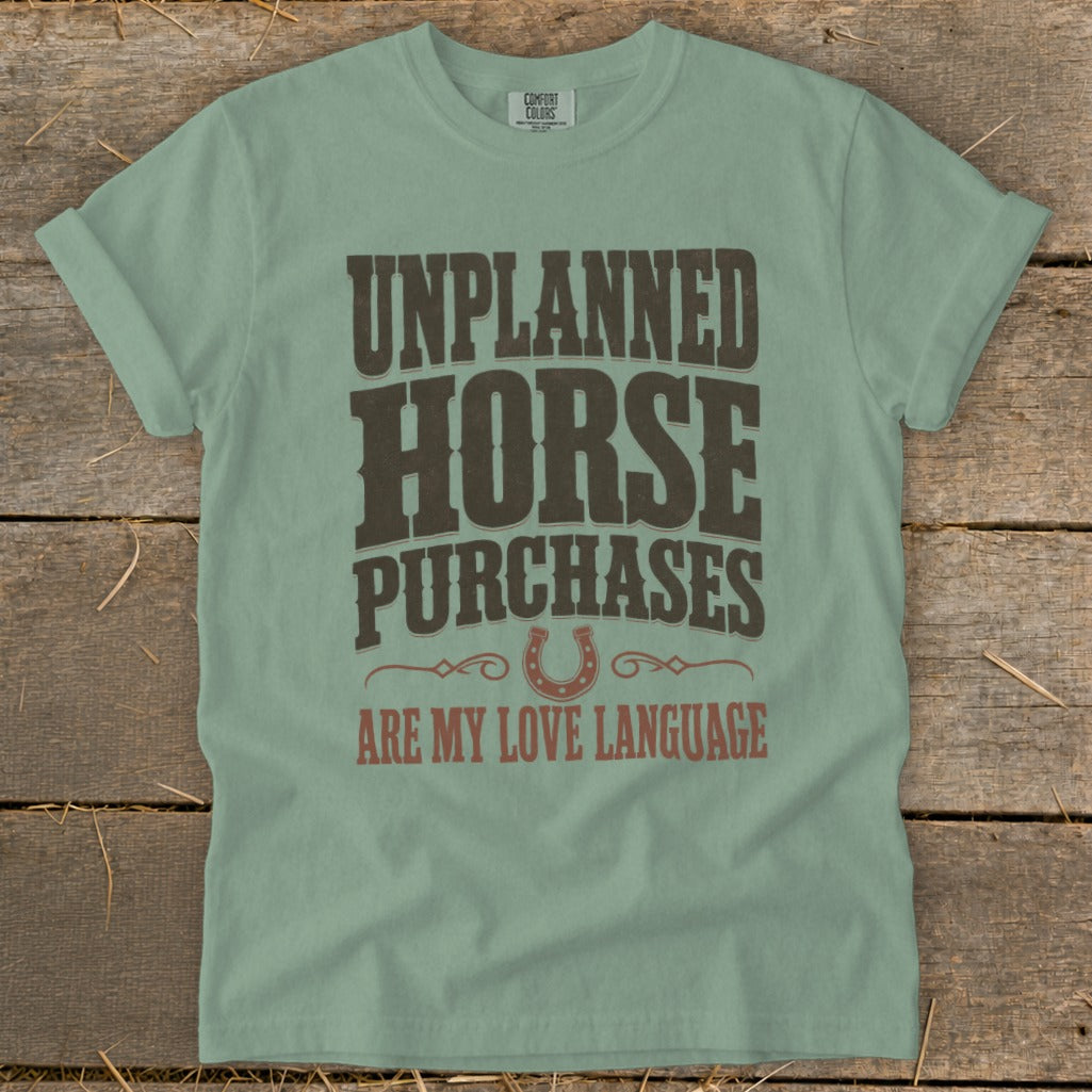 Green t-shirt with text: Unplanned Horse Purchases Are My Love Language and horseshoe graphic.