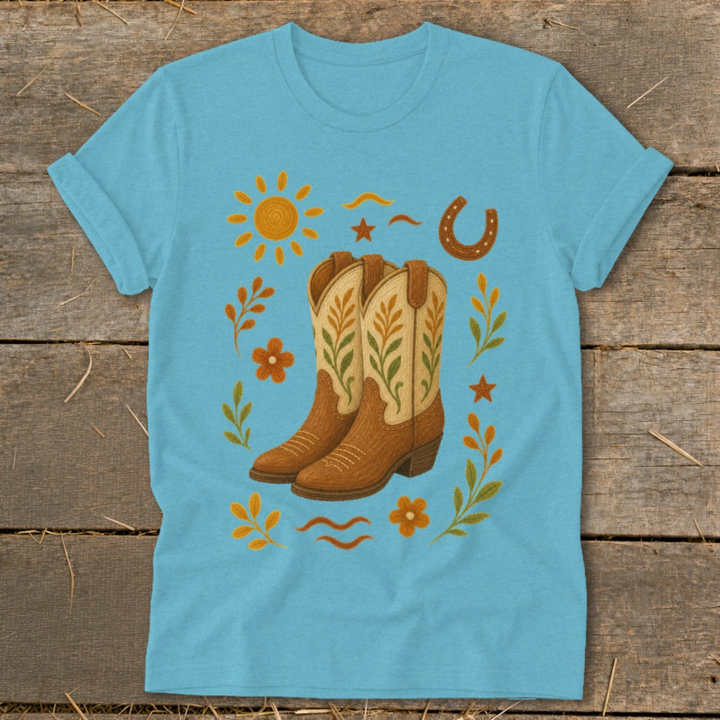 Turquoise t-shirt with embroidered cowboy boots, sun, horseshoe, and floral elements.