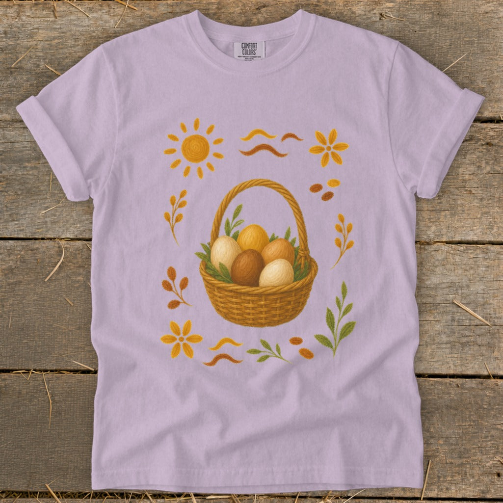 Light purple t-shirt with a basket of Easter eggs and floral accents.