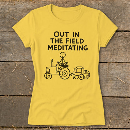 Yellow t-shirt with "Out in the Field Meditating" text and a stick figure meditating on a tractor.
