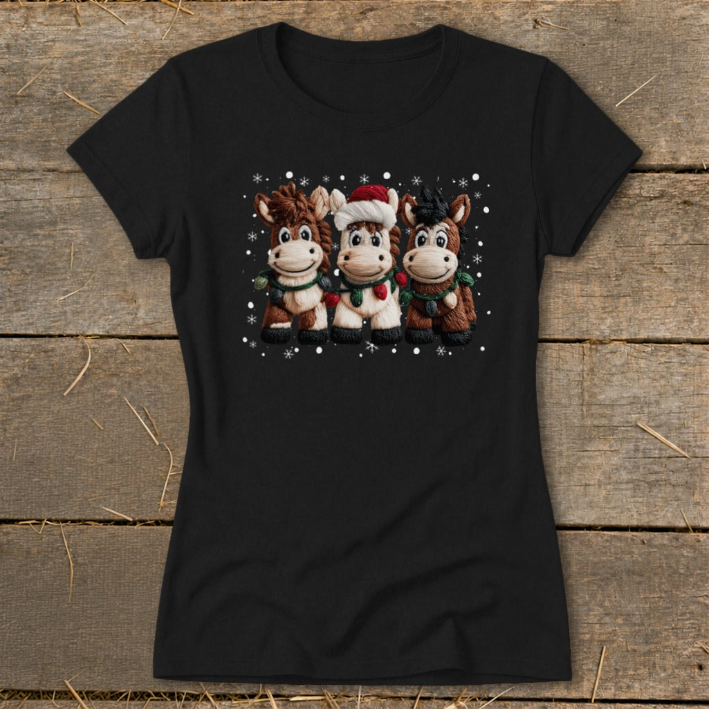 Black t-shirt with three cartoon horses wearing Christmas hats and scarves.