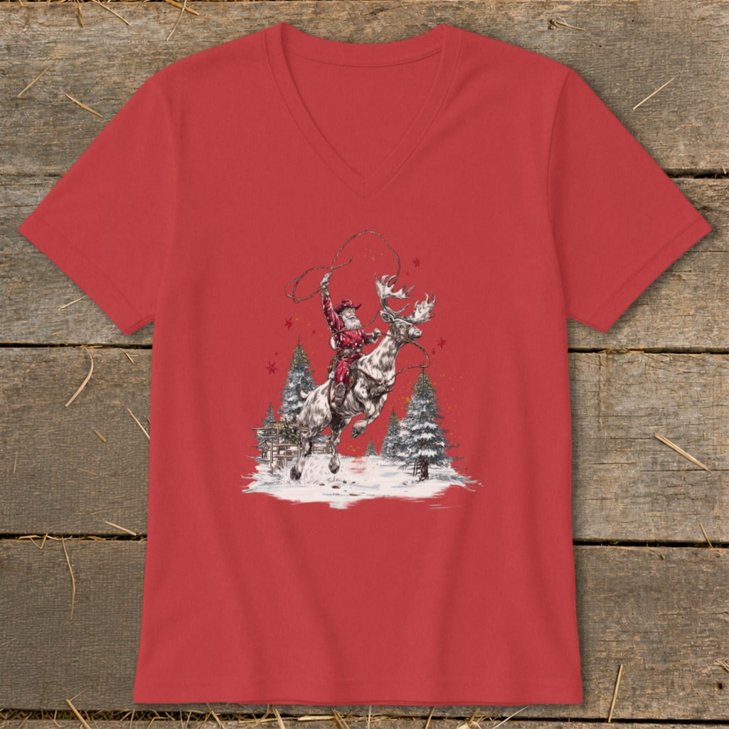 Red t-shirt featuring Santa riding a reindeer with a lasso and snowy trees.