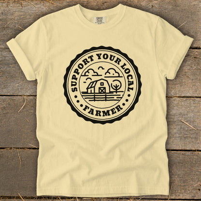Light yellow t-shirt with black circular "Support Your Local Farmer" graphic.