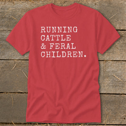 Red t-shirt with white text reading "RUNNING CATTLE & FERAL CHILDREN."