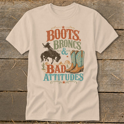 T-shirt graphic with boots, broncs, and bad attitudes text, cowboy, and boots.