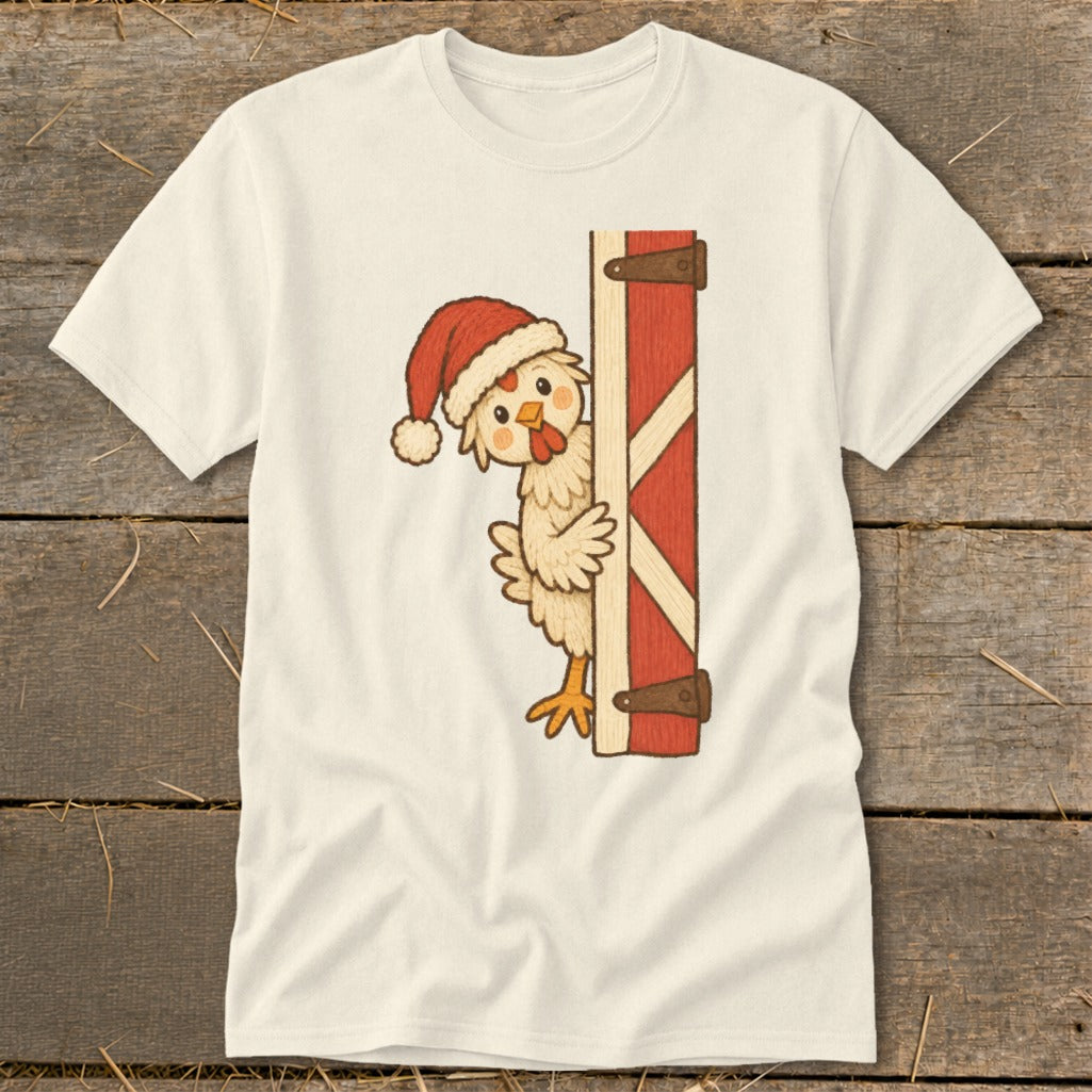 Cream t-shirt with illustration of a chicken wearing a Santa hat peeking from behind a red barn door.